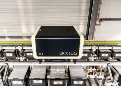 Autonomiczny Robot BOxSS Znajdujący Się Na Szynie Umieszczonej Na Górze Regałów Magazynowych